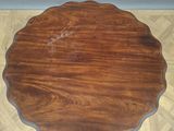a round table with a wooden top on a parquet floor