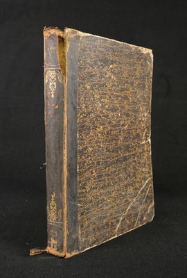 an old book sitting on top of a black table next to a black background