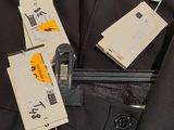 a suit jacket with tags on it hanging on a hanger