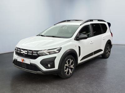 La voiture blanche est garée dans une pièce au sol noir.