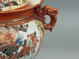 a vase with a lid that has a design on it