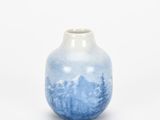 a blue and white vase sitting on top of a white table