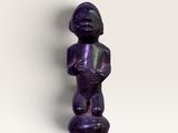une image représentant une figurine violette posée sur une surface blanche
