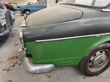 a green and black car parked in a parking lot