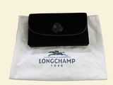 a longchamp purse sitting on top of a white bag