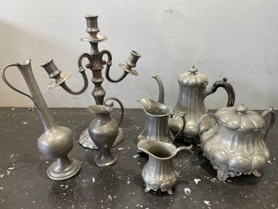 un ensemble de vases en argent et un candélabre posés sur une table