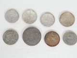 several different coins are arranged in a row on a white surface