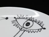 a white plate with a drawing of an eye on it