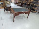 a table with a black top and a chair in the middle of a room