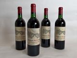 three bottles of red wine are lined up on a table