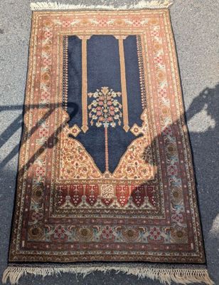 une image représentant un tapis posé au sol, avec l'ombre d'une personne