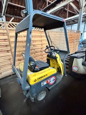 un chariot élévateur dans un entrepôt avec des palettes à l'arrière-plan