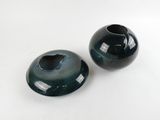 two black vases sitting on a white surface