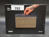 a close up of a box of a speaker with a hand on it
