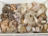 une boîte blanche remplie de nombreuses sortes de pierres différentes