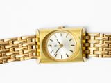 a gold watch with a white face on a gold bracelet