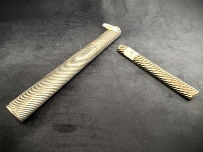 pair of antique brass - plated razors on a black background