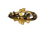 an image of a gold broochle with a cross on it