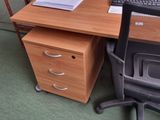 a desk with a computer and a chair in the room
