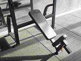 a black and white photo of a bench in a gym