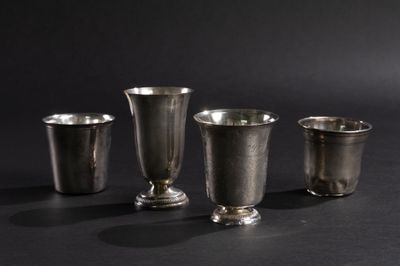 trois coupes en argent posées les unes à côté des autres sur une surface noire