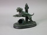 a statue of a dog that is jumping over a pipe