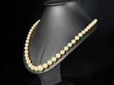 un gros plan d'un collier porté par un mannequin sur fond noir