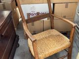 une chaise en bois avec une assise tressée dans une pièce