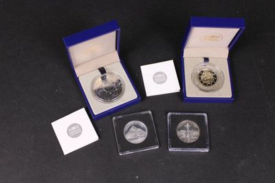 deux pièces d'argent et une pièce d'argent dans une boîte bleue posée sur une surface noire