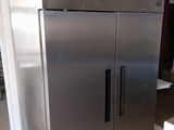 a stainless steel refrigerator in the middle of a room