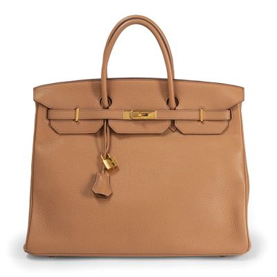 a tan leather handbag with gold hardware on the handle