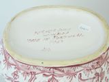 a red and white vase with writing on it