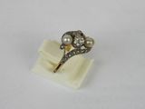 a close up of a ring with pearls on a white surface