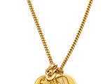 a close up of a gold necklace with a coin on it