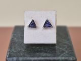 a close up of a pair of earrings on top of a marble block