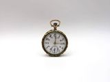 a close up of a pocket watch on a white surface