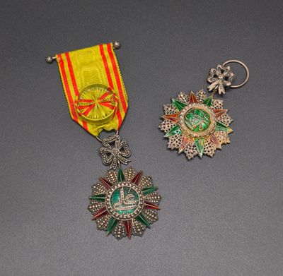 two medals and a medal on a table with a gray background
