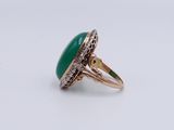 a close up of a ring with a green stone in it