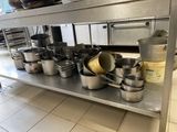many pots and pans on a metal shelf in the kitchen