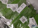 several pairs of green socks are wrapped in plastic bags on a table