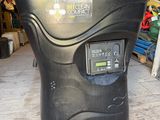 a black trash can sitting on a wooden floor in a garage