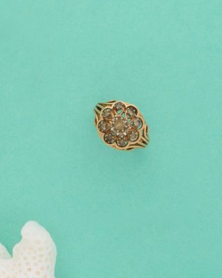 Gros plan sur une bague en or ornée d'une fleur
