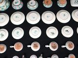 many cups and saucers that are on a black table