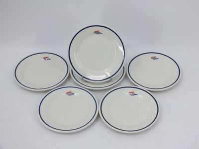six assiettes blanches et bleues, bordées de bleu, sont disposées sur une surface blanche