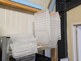 une pile de récipients en plastique posée sur une étagère dans un garage