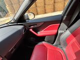 the interior of a car with red leather seats and a steering wheel
