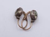 pair of antique silver earrings with green glass beads on a white background