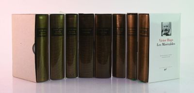 several books are lined up in a row on a white surface