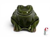 a green frog figurine sitting on a white surface