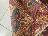 a close up of a red and blue rug on a tiled floor